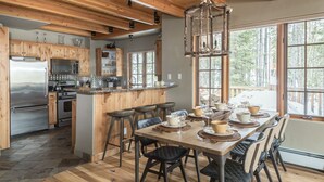 Cozinha moderna com armários de madeira, eletrodomésticos de aço inoxidável e uma ilha grande com banquetas.
