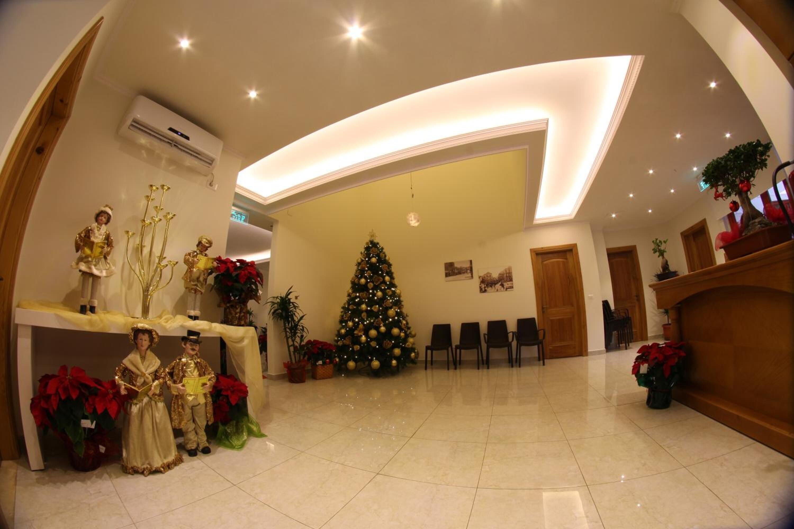 Un hall d’entrée spacieux, agrémenté d’un sapin de Noël, d’un espace salon et d’un comptoir d’accueil.