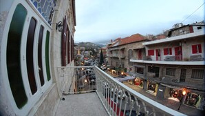 A street view from a balcony overlooking a busy urban area with shops and buildings. - Hôtel Saint Jean Zahle (Zahlé)
