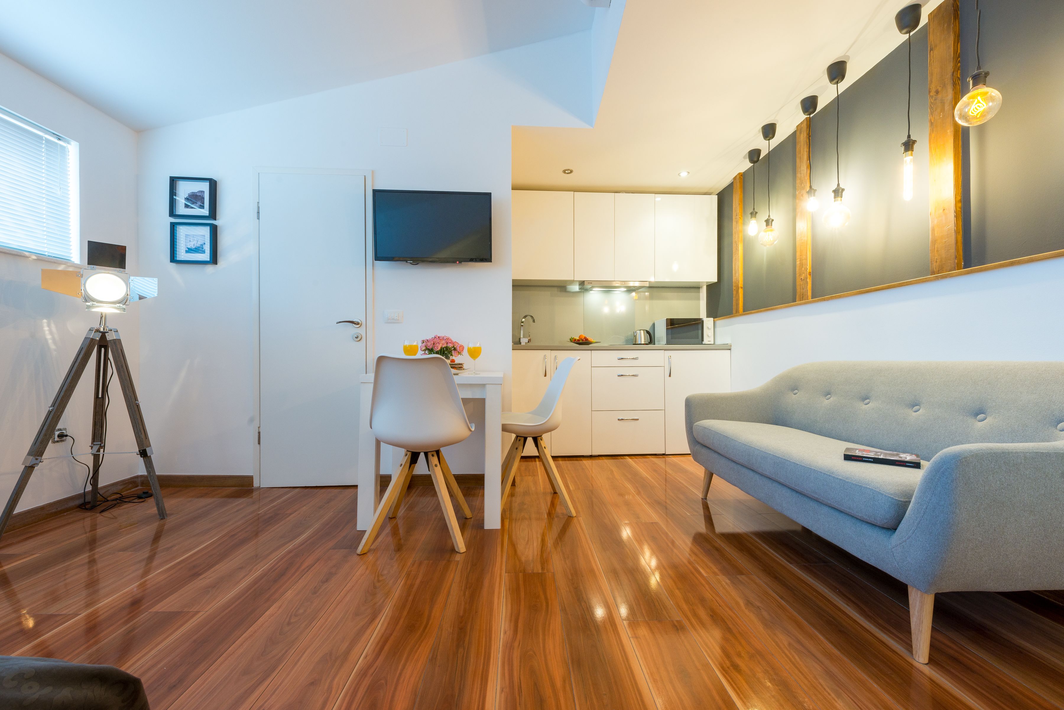 A compact living space with a kitchenette, a sofa, and a dining area.