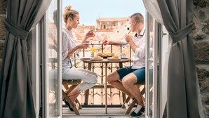 A couple dining at a table with a view of a historic building. - Scalini Palace (Dubrovnik)