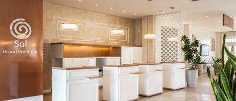 A modern kitchen with white cabinetry, pendant lighting, and a central island.