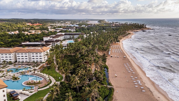 Un complexe hôtelier doté d’une grande piscine, d’une plage et offrant une vue sur l’océan.