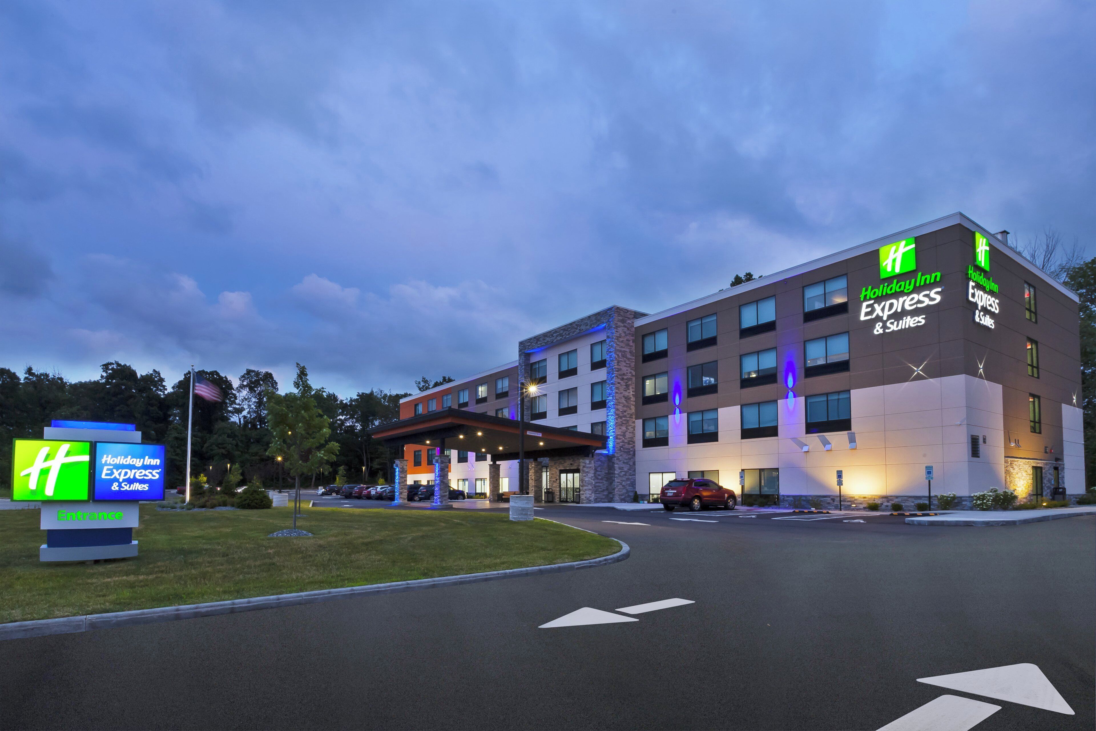A Holiday Inn Express & Suites hotel with a modern design, featuring a well-lit entrance and clear signage.