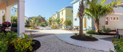 A residential area with houses, a gravel pathway, and a parked motorcycle.