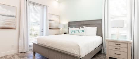 A bedroom with a bed, bedside tables, and a window with curtains.