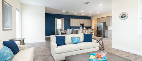 A modern living room with a sofa, coffee table, and a ceiling fan.