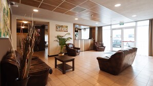 A spacious lobby with leather sofas, a coffee table, and a potted plant. - Areo Hotel & Restaurant (Odorheiu Secuiesc)