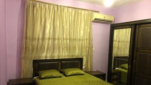 A bedroom with a bed, nightstands, a wardrobe, and a mirror. - Sea View Luxury Furnished Flat (Aqaba)