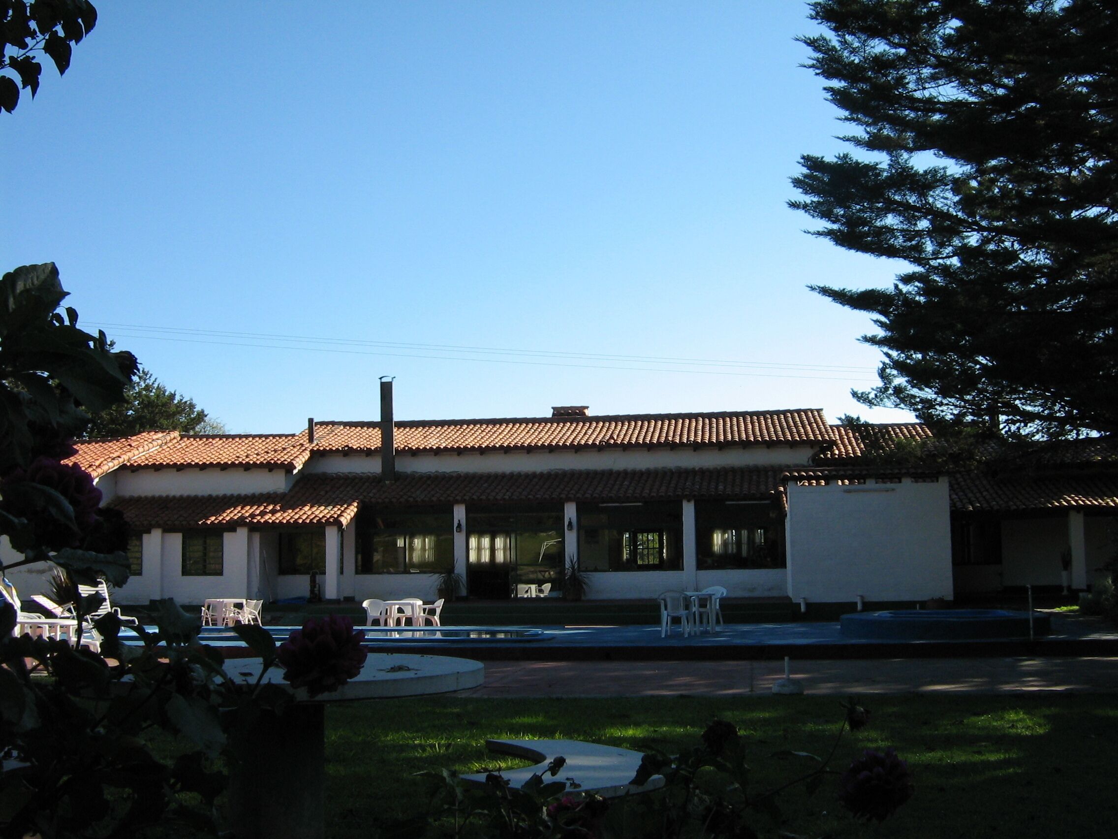 A building with a tiled roof and a covered patio area with outdoor seating.
