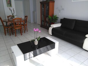 Relax in this stylish living room with a sofa, coffee table, and dining area.