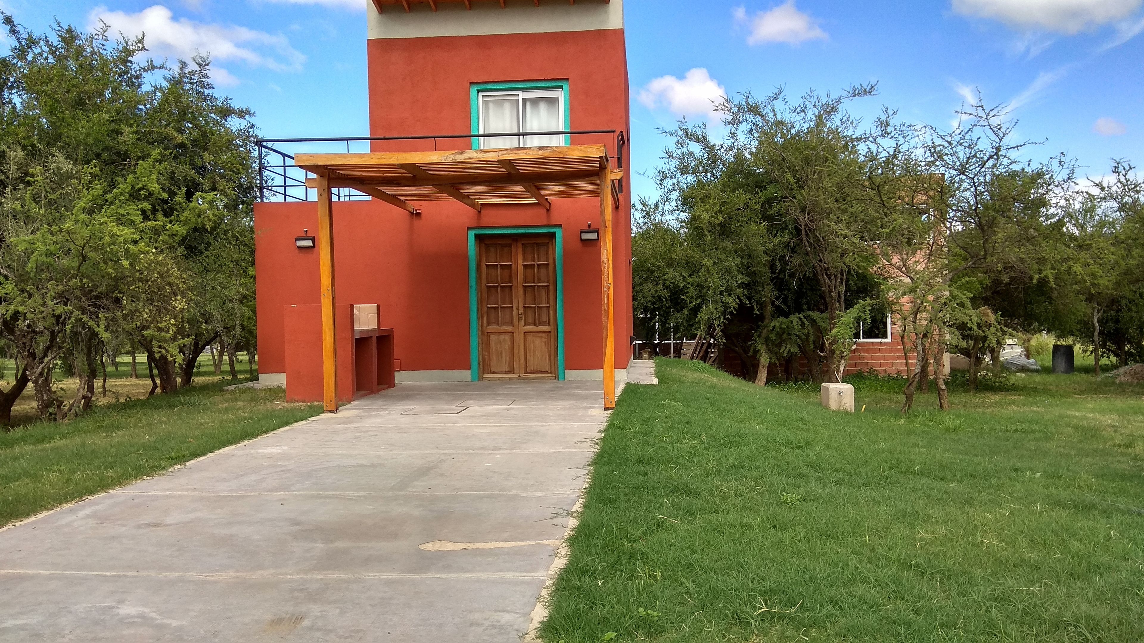 A building with a red facade, a wooden door, and a covered entrance.