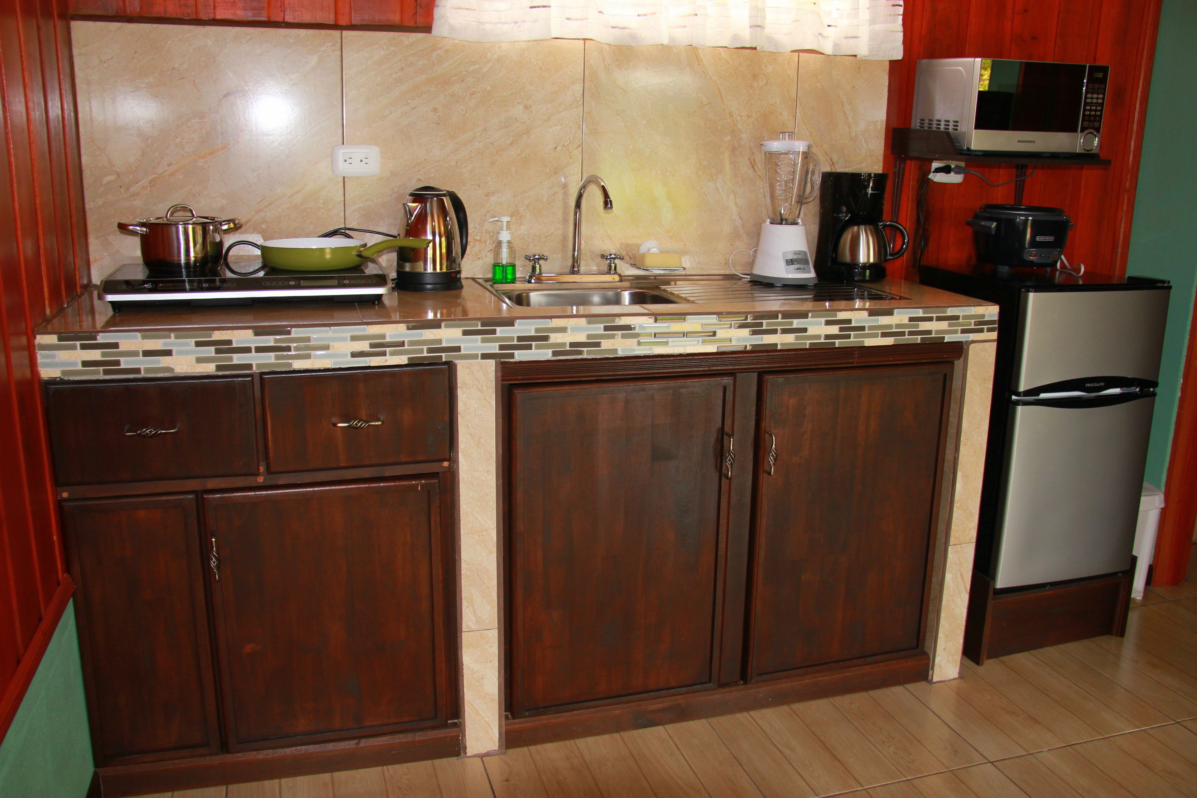 A kitchen with wooden cabinets, a built-in stove, a microwave, and a refrigerator.