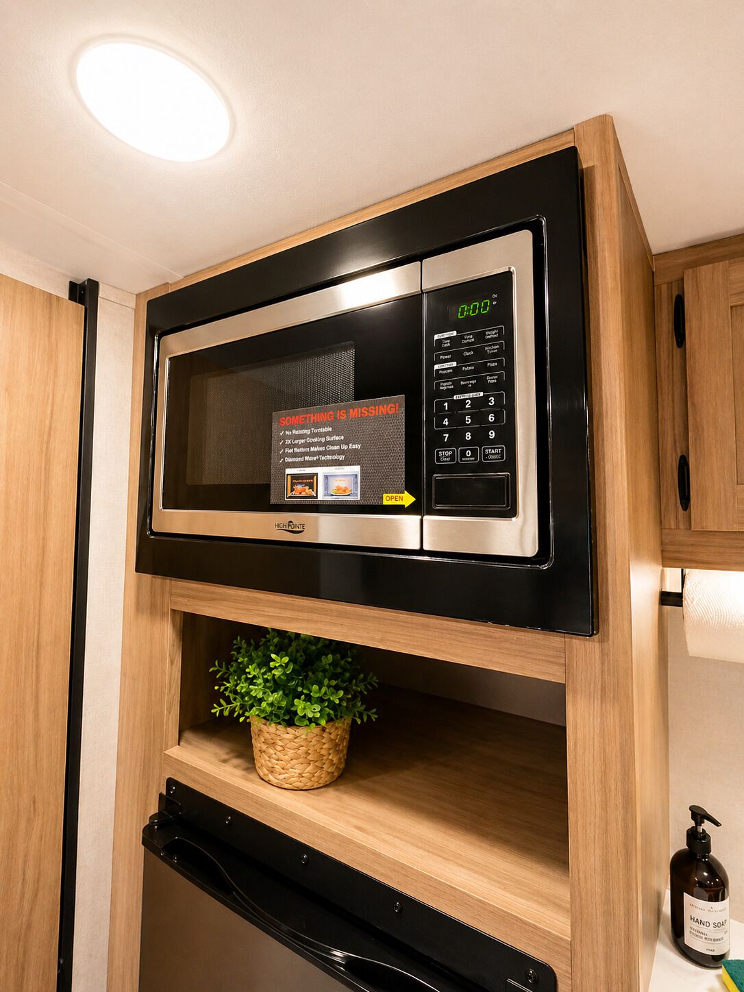 A microwave oven with a digital display and control panel, mounted on a wooden cabinet.