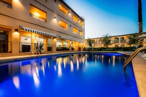 A hotel with a swimming pool, multiple balconies, and a well-lit facade. - Sleep Inn Monterrey Norte (San Nicolas de los Garza)