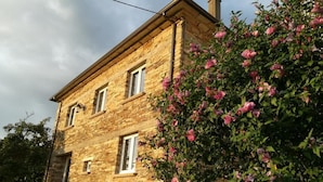 Un bâtiment en pierre doté d’un toit à pignon et de nombreuses fenêtres.