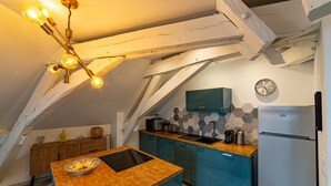 A kitchen with a wooden island, a built-in oven, a sink, and a refrigerator. - "Happy Cocoon" - Immersion in the historic center (Blois)