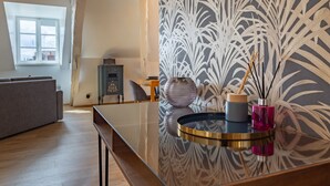 A modern living room with a glass coffee table, a decorative vase, and a patterned wall. - "Happy Cocoon" - Immersion in the historic center (Blois)