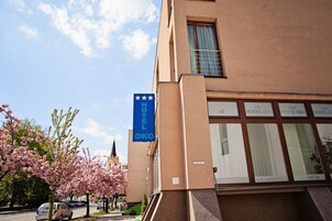 Un edificio de hotel con un letrero azul que indica que es un establecimiento de 3 estrellas.