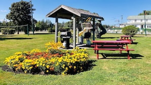 A park with a playground, picnic tables, and a barbecue grill. - Anne Shirley Motel & Cottages (Cavendish)