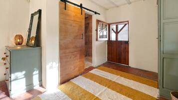 Un couloir avec un tapis à rayures, une porte en bois et une porte coulissante de style grange.