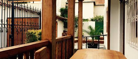 A wooden table in a covered outdoor area with a sign for 'Esencia Hotel Boutique & Gourmet'.
