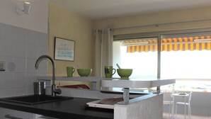 Eine Küche mit Waschmaschine, Spüle und einem Fenster mit Blick.