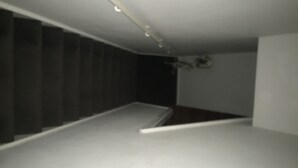 A narrow, dimly lit room with a sloped ceiling and a single, low-profile bed. - Terraced house available for holiday vacation (London)
