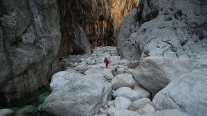 A rocky canyon with large boulders and a narrow passageway. - LUMINOUS SEA VIEWS IN SARDINIA, IDEAL FOR COUPLES OF FRIENDS AND FAMILIES! (Cala Gonone)