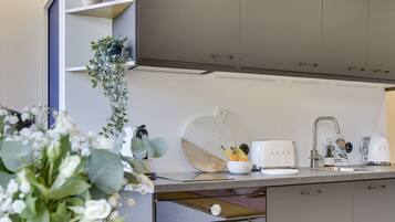 Een koelkast, een kookplaat, een vaatwasser, een waterkoker