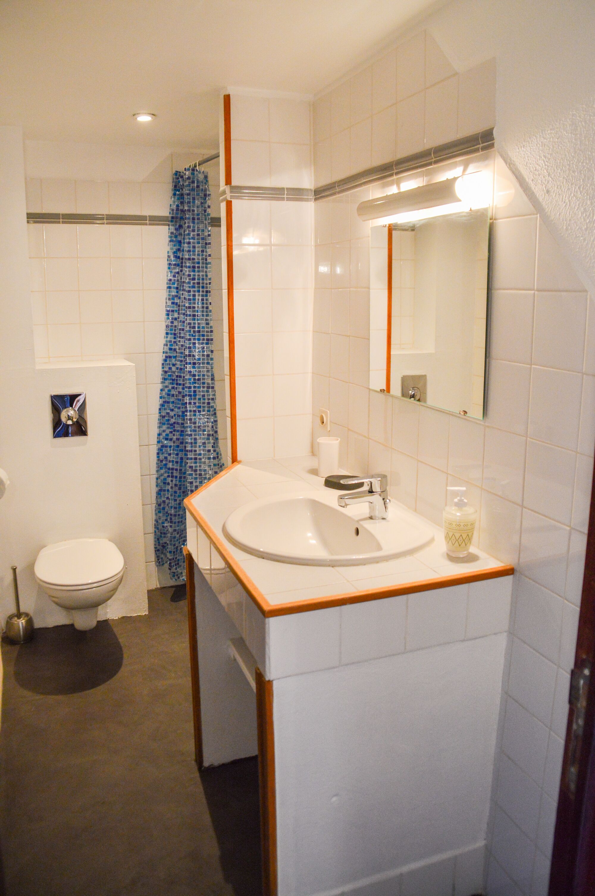 Ein Badezimmer mit Waschbecken, Spiegel und Toilette.