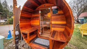 A wooden cabin with a circular interior, a glass door, and a bench outside. - The Islander Inn (Bigfork)
