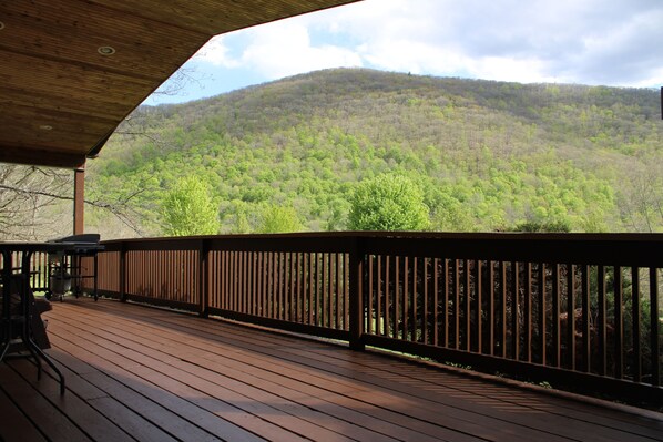 A wooden deck with a railing, overlooking a forested hillside. - Elk from the Hot Tub - Bugle Inn (Weedville)