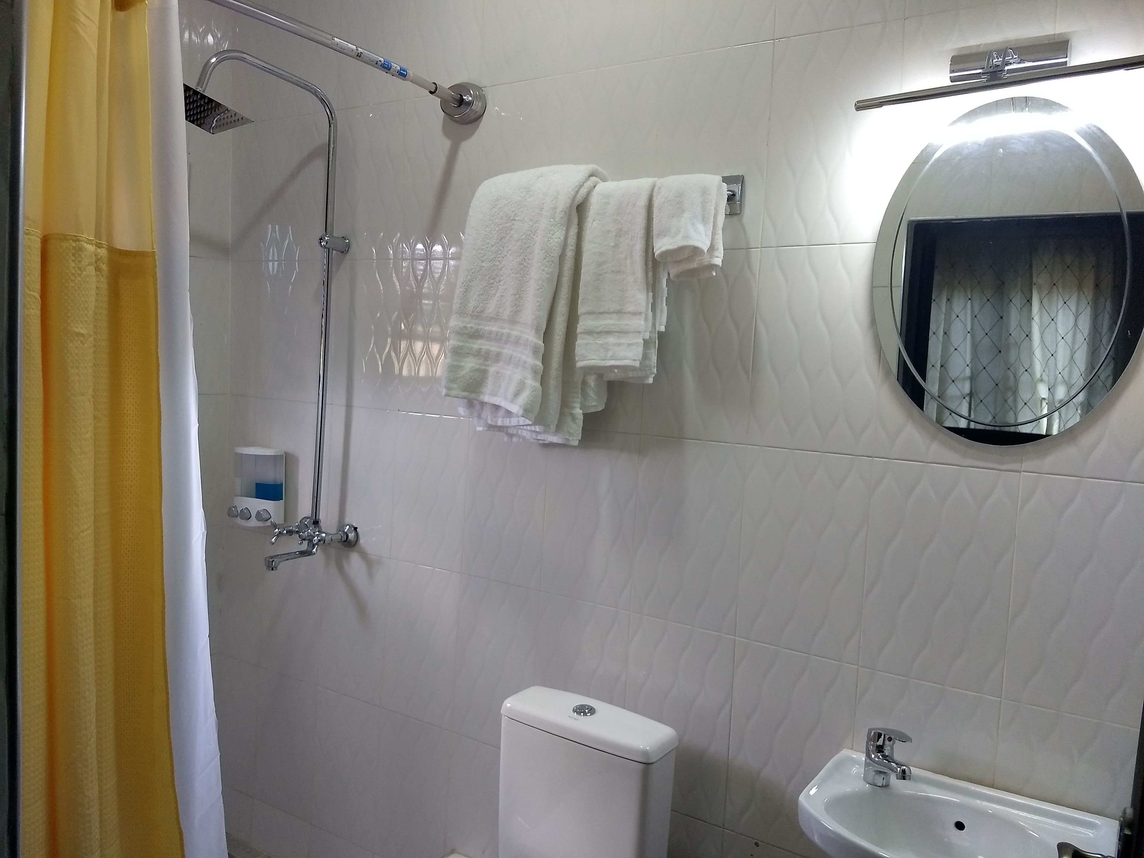 Kylpyhuone, jossa on suihku, wc, pesuallas ja peili.