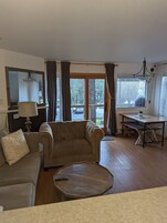 Una sala de estar con sofá, mesa de centro, mesa de comedor y candelabro.