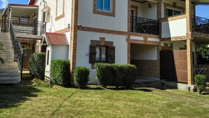 A two-story house with a balcony, a staircase, and a small garden area. - La Rivière St Louis, 2-room apartment "Furnished tourist accommodation 3 *** (Le Ouaki)
