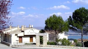 A building named "EL MOLINO" with a stone facade and a view of the sea.