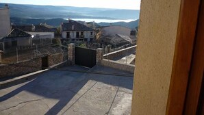A view from a balcony overlooking a residential area with houses and a distant body of water.
