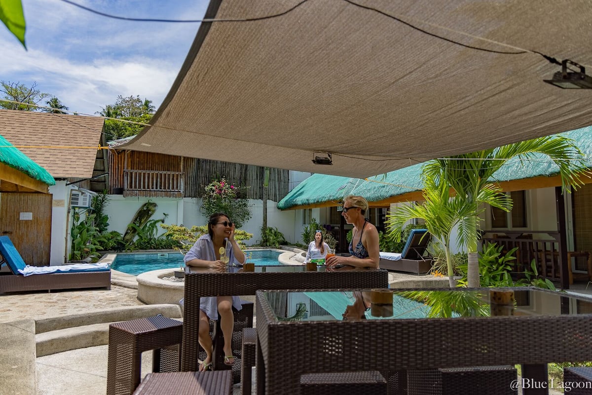 A poolside area with lounge chairs, a small pool, and shaded seating areas.
