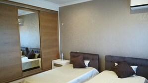 A hotel room with two beds, a large mirror, a small bedside table, and a wall-mounted air conditioner. - HOUSE WITH SWIMMING POOL AND BARBECUE (Vila Boim)