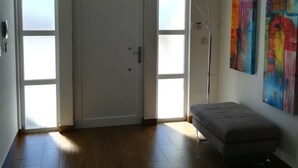 A spacious room with a large door, a bench, and two windows. - HOUSE WITH SWIMMING POOL AND BARBECUE (Vila Boim)