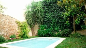 A rectangular swimming pool surrounded by a well-maintained lawn and various plants. - Self catering Cal Cabrer for 12 people (Sant Jaume dels Domenys)