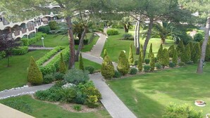 A well-maintained garden with a pathway, neatly trimmed hedges, and a variety of trees. - CHARMING STUDIO RESIDENCE SECURE WITH 3 POOLS - LARGE TERRACE + PARKING (Mandelieu-la-Napoule)