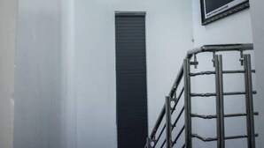 Una escalera con barandilla de metal, una lámpara y un cartel en la pared.