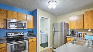 A kitchen with wooden cabinets, stainless steel appliances, a microwave, oven, refrigerator, and a sink. - Patio Dining, 7 Mi to Purdue: Family Escape! (Lafayette)