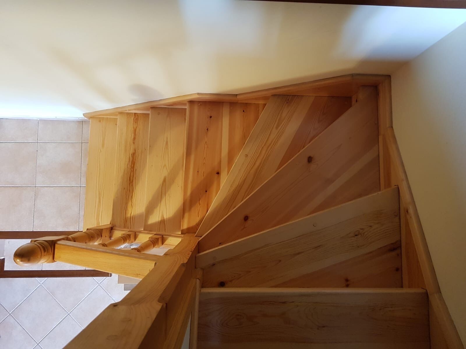 Een houten trap met een eenvoudig ontwerp, die naar een hoger gelegen verdieping leidt.