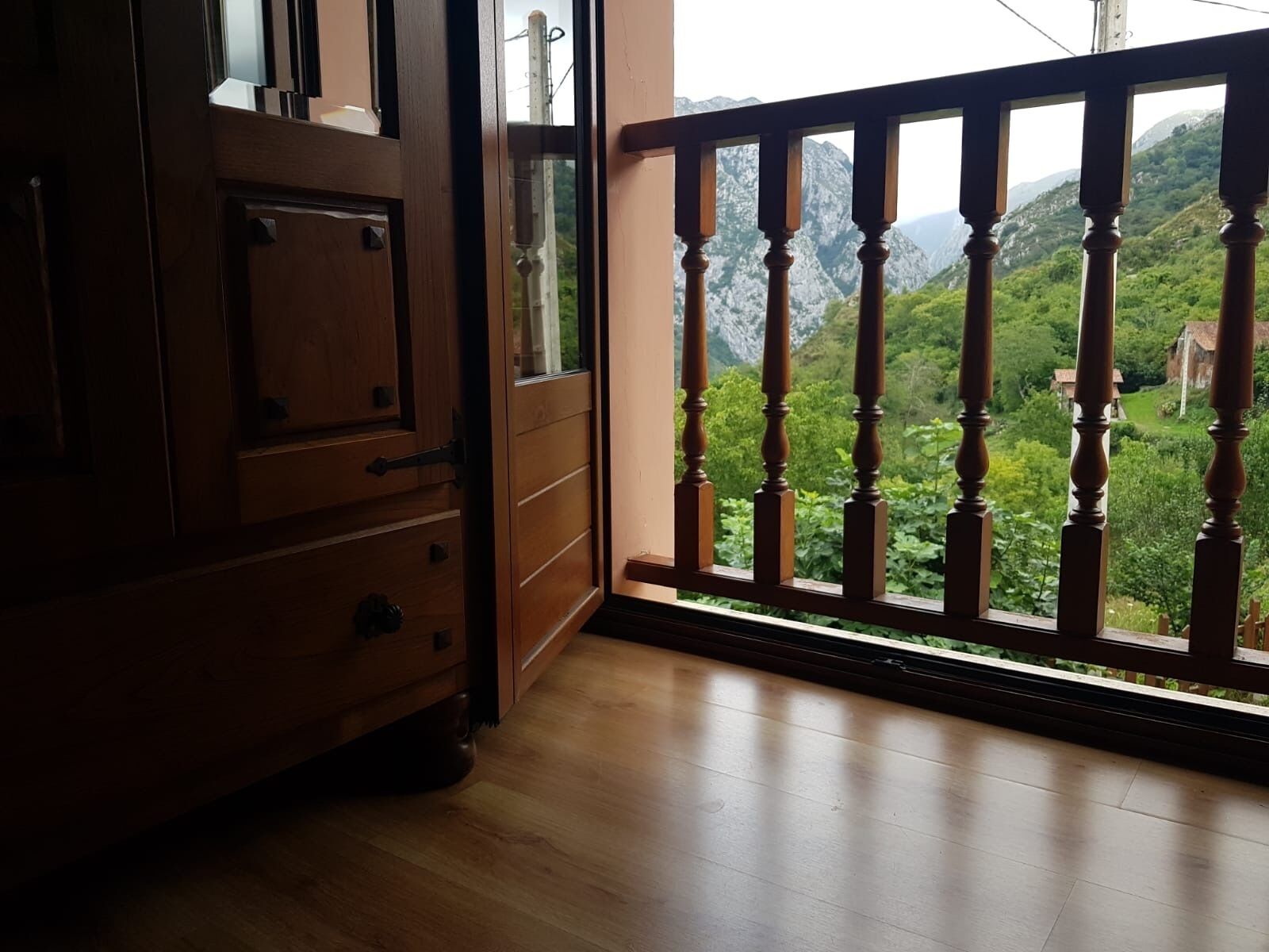 Une pièce en bois avec un balcon donnant sur un paysage montagneux.