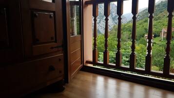 Une pièce en bois avec un balcon donnant sur un paysage montagneux.