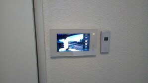 En övervakningskamera och en kontrollpanel på en vägg.