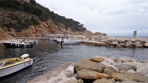 A rocky shoreline with boats docked near the water's edge. - VILLA FACING THE SEA IN CALANQUE COTE BLEUE (Ensuès-la-Redonne)